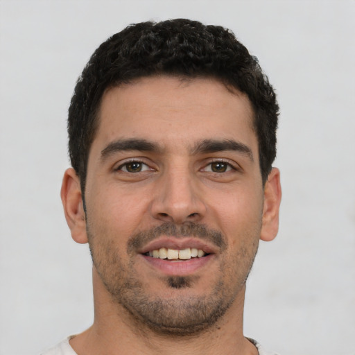 Joyful white young-adult male with short  black hair and brown eyes
