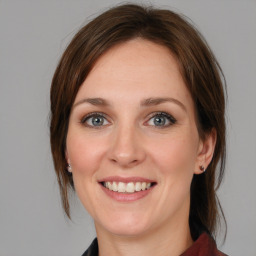 Joyful white young-adult female with medium  brown hair and blue eyes