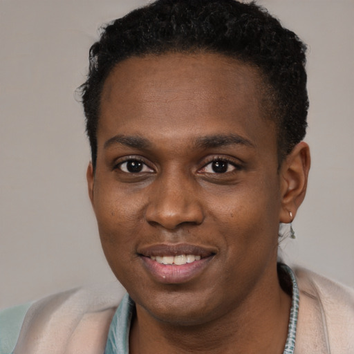 Joyful black young-adult male with short  brown hair and brown eyes