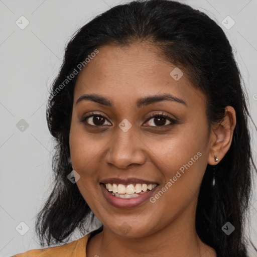 Joyful black young-adult female with long  brown hair and brown eyes