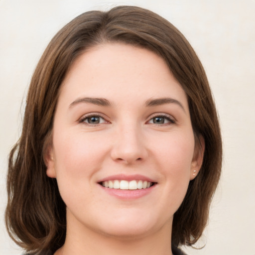 Joyful white young-adult female with medium  brown hair and green eyes