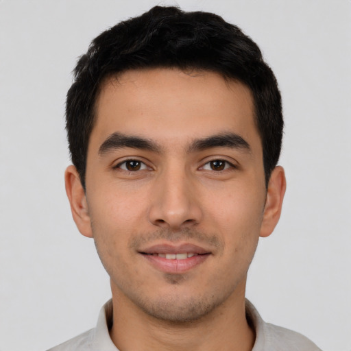 Joyful latino young-adult male with short  brown hair and brown eyes