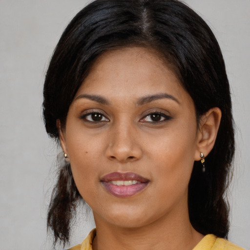 Joyful black young-adult female with long  black hair and brown eyes