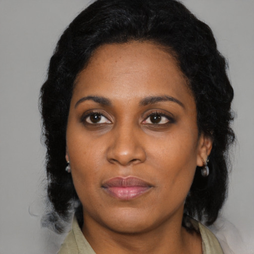 Joyful black adult female with long  black hair and brown eyes