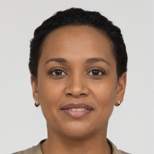 Joyful black young-adult female with short  black hair and brown eyes