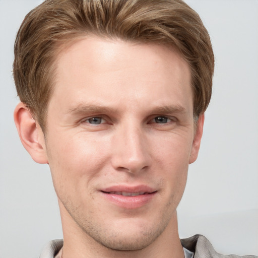 Joyful white young-adult male with short  brown hair and grey eyes