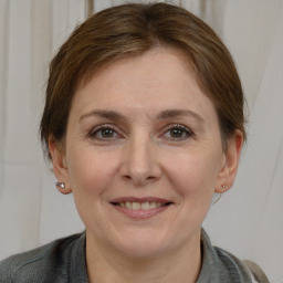 Joyful white adult female with medium  brown hair and grey eyes