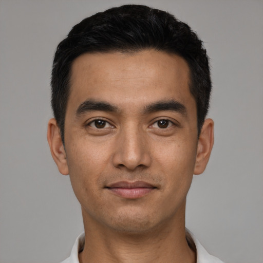 Joyful latino young-adult male with short  black hair and brown eyes