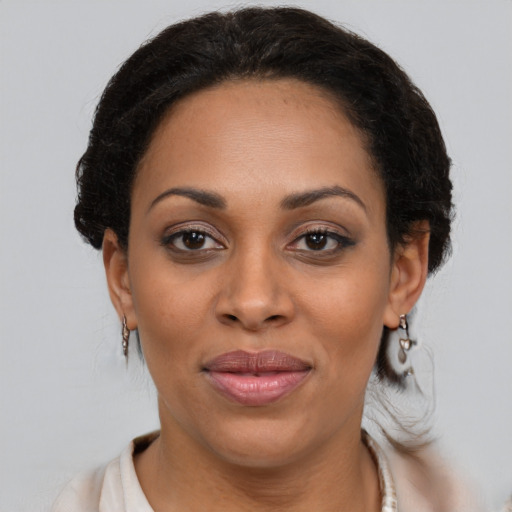 Joyful black adult female with medium  brown hair and brown eyes