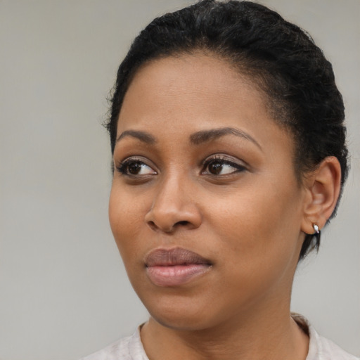 Joyful black young-adult female with short  black hair and brown eyes