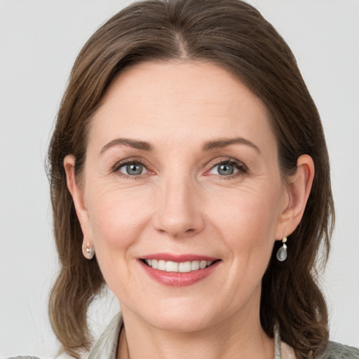 Joyful white adult female with medium  brown hair and grey eyes