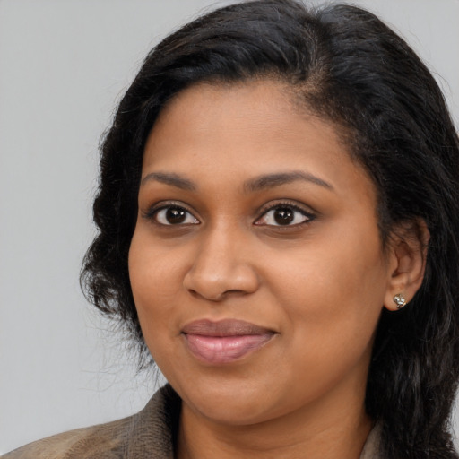 Joyful black young-adult female with long  brown hair and brown eyes
