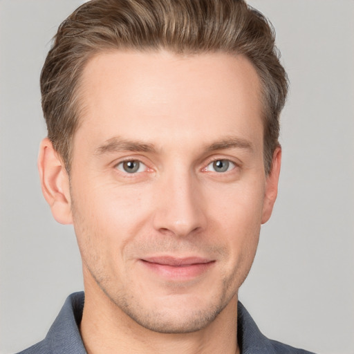 Joyful white young-adult male with short  brown hair and grey eyes