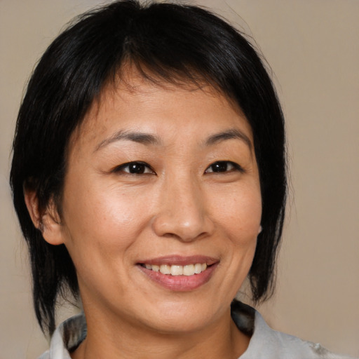 Joyful asian adult female with medium  brown hair and brown eyes