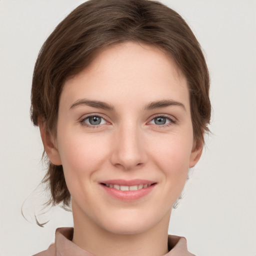 Joyful white young-adult female with short  brown hair and grey eyes