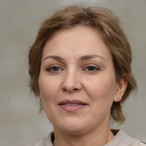 Joyful white adult female with medium  brown hair and grey eyes