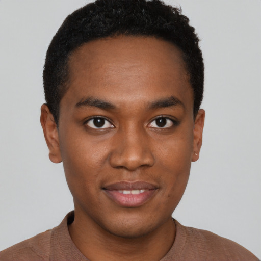 Joyful black young-adult male with short  brown hair and brown eyes