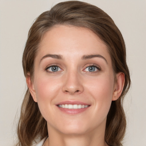 Joyful white young-adult female with long  brown hair and blue eyes