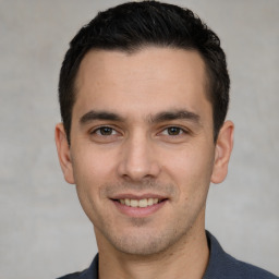 Joyful white young-adult male with short  black hair and brown eyes