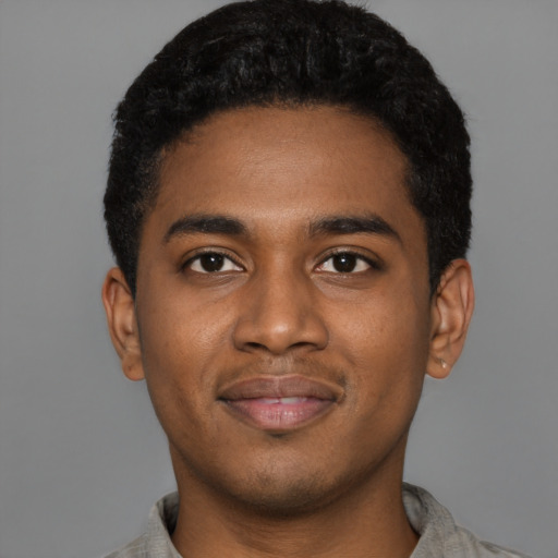 Joyful black young-adult male with short  black hair and brown eyes