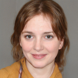 Joyful white young-adult female with medium  brown hair and blue eyes