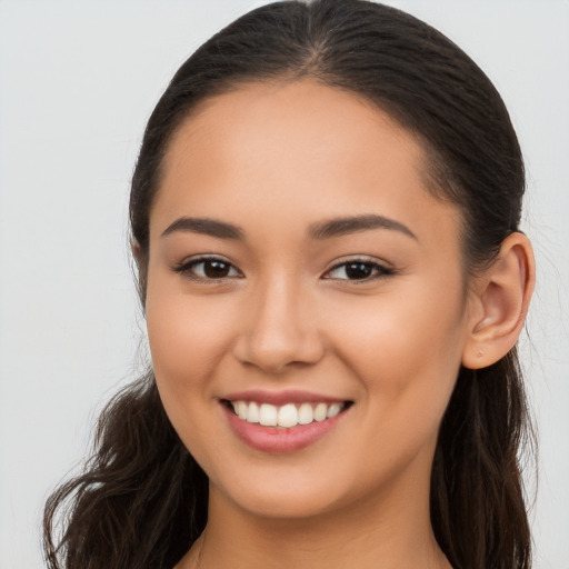 Joyful latino young-adult female with long  brown hair and brown eyes