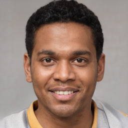 Joyful latino young-adult male with short  black hair and brown eyes