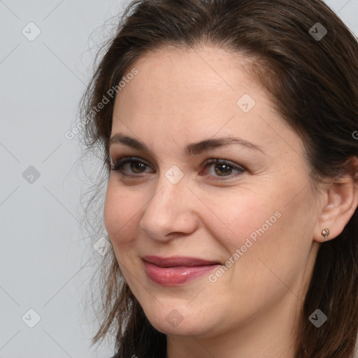 Joyful white young-adult female with long  brown hair and grey eyes