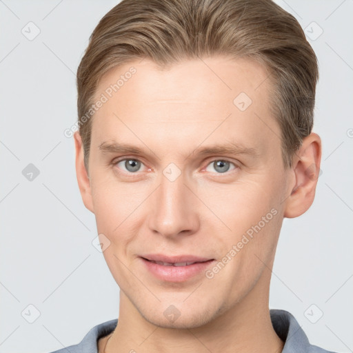 Joyful white young-adult male with short  brown hair and grey eyes