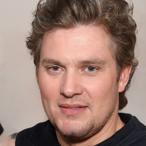 Joyful white adult male with medium  brown hair and brown eyes