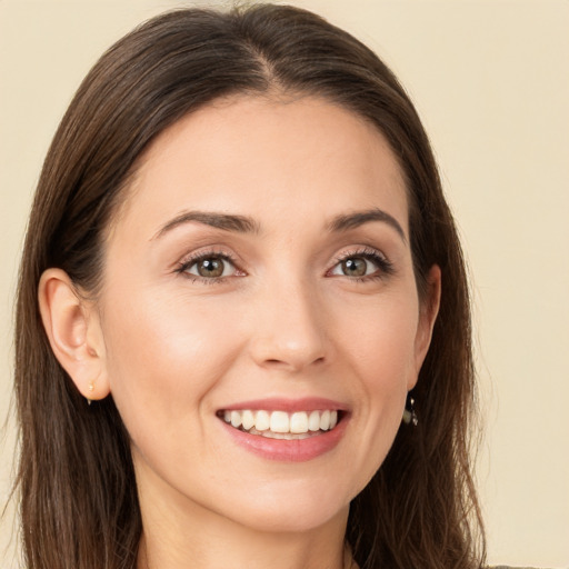 Joyful white young-adult female with long  brown hair and brown eyes