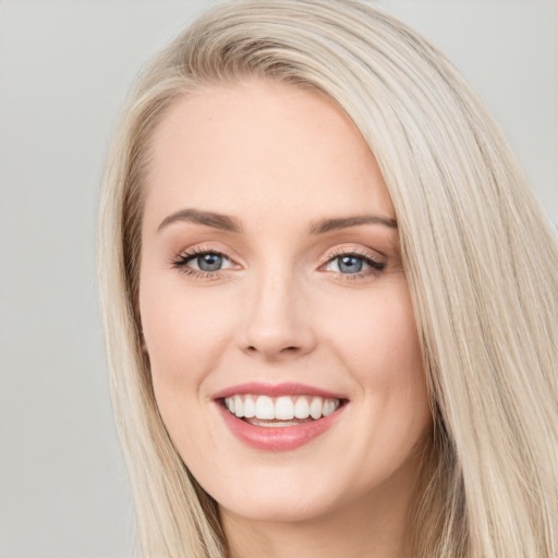 Joyful white young-adult female with long  brown hair and blue eyes