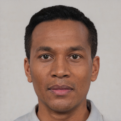 Joyful black adult male with short  black hair and brown eyes