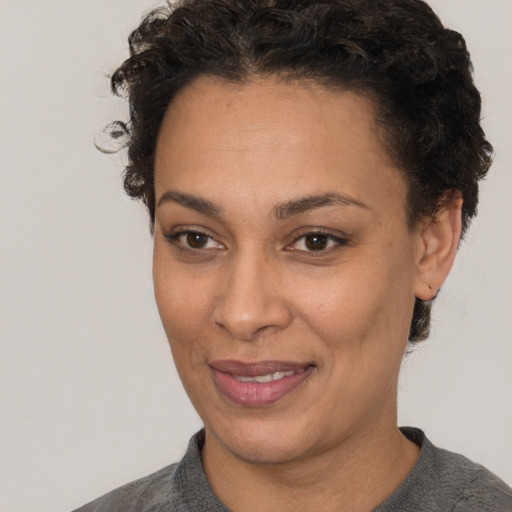 Joyful white adult female with short  black hair and brown eyes
