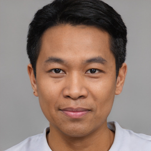 Joyful asian young-adult male with short  black hair and brown eyes
