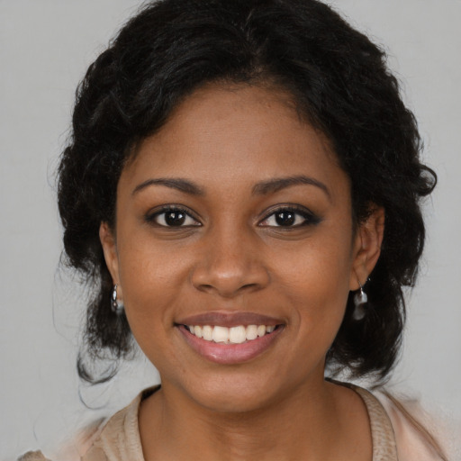 Joyful black young-adult female with long  brown hair and brown eyes