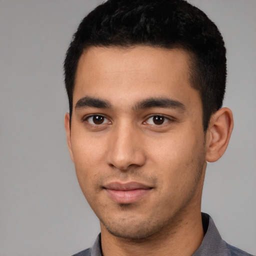 Joyful latino young-adult male with short  black hair and brown eyes