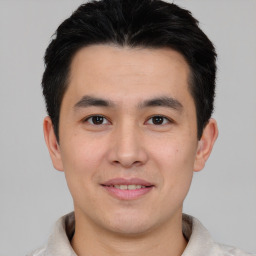 Joyful asian young-adult male with short  black hair and brown eyes