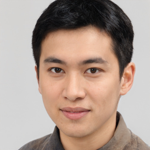 Joyful asian young-adult male with short  brown hair and brown eyes