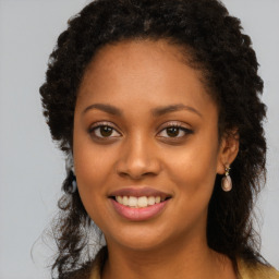 Joyful black young-adult female with long  brown hair and brown eyes