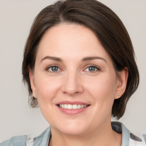 Joyful white adult female with medium  brown hair and grey eyes