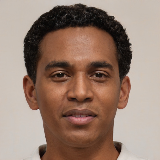 Joyful black young-adult male with short  black hair and brown eyes