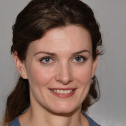 Joyful white young-adult female with medium  brown hair and blue eyes