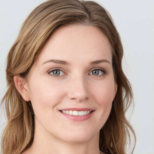 Joyful white young-adult female with long  brown hair and blue eyes