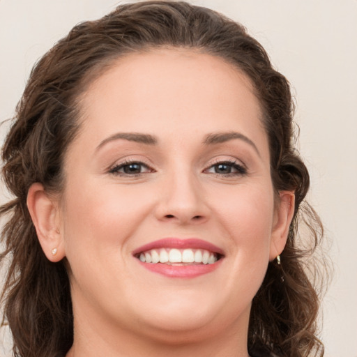 Joyful white young-adult female with long  brown hair and grey eyes