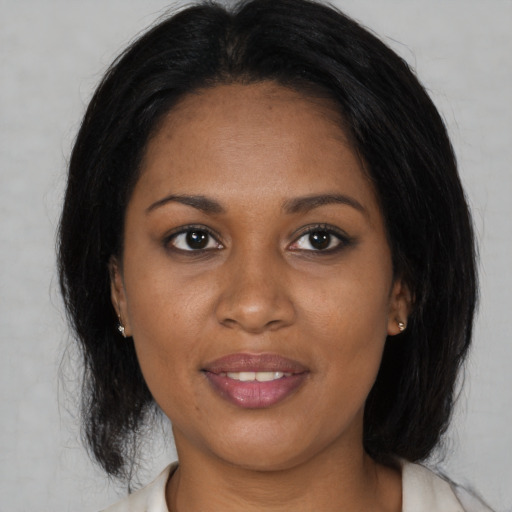 Joyful black adult female with medium  brown hair and brown eyes