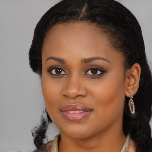 Joyful black young-adult female with long  brown hair and brown eyes