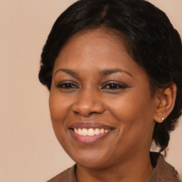 Joyful black adult female with medium  brown hair and brown eyes