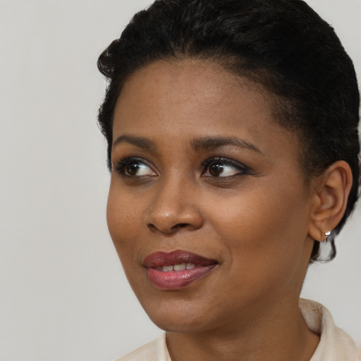 Joyful black young-adult female with short  black hair and brown eyes