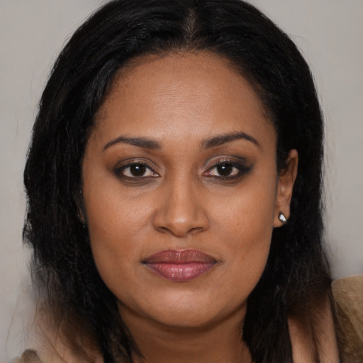 Joyful black young-adult female with long  brown hair and brown eyes